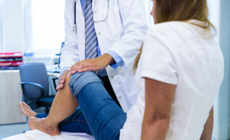 Male Podiatrist examining patients knee