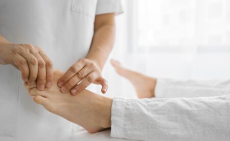 Healthcare professional examining a patient's foot and diagnosing foot problems