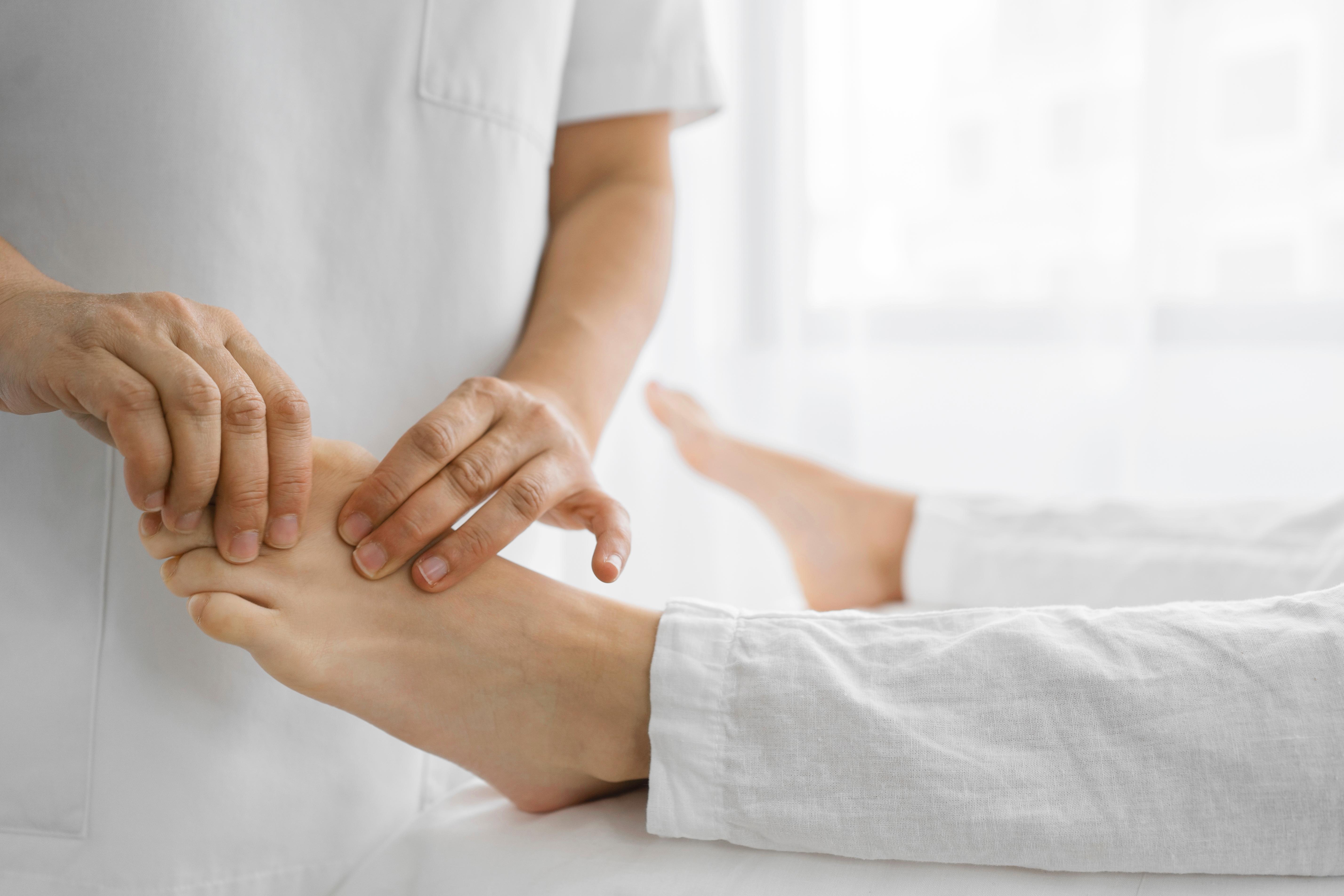 Healthcare professional examining a patient's foot and diagnosing foot problems