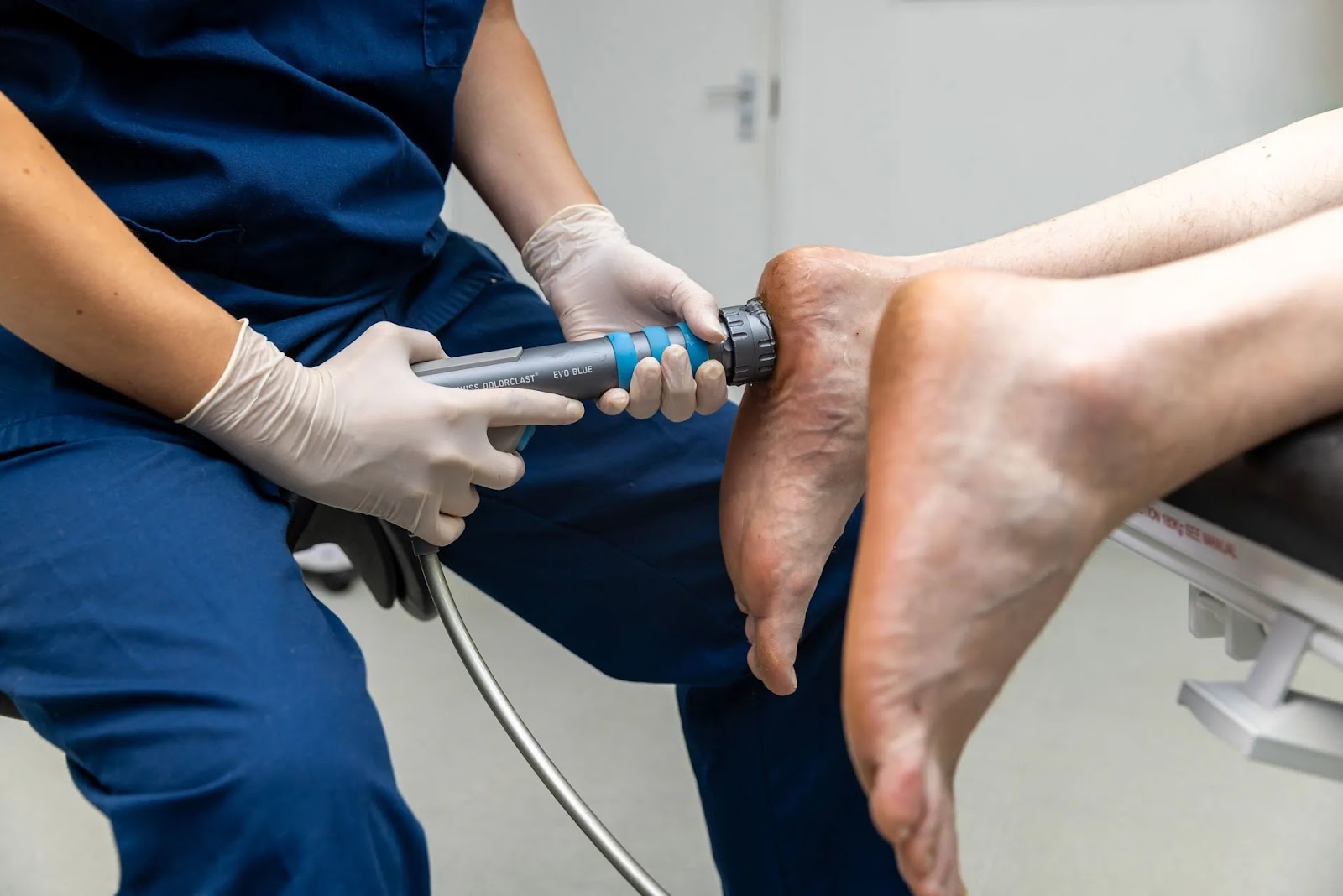 Podiatrist performing shockwave therapy on heel to treat plantar fasciitis and heel pain