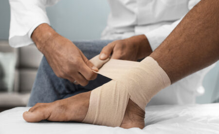 Diabetic podiatrist applying compression bandage for diabetic foot care treatment